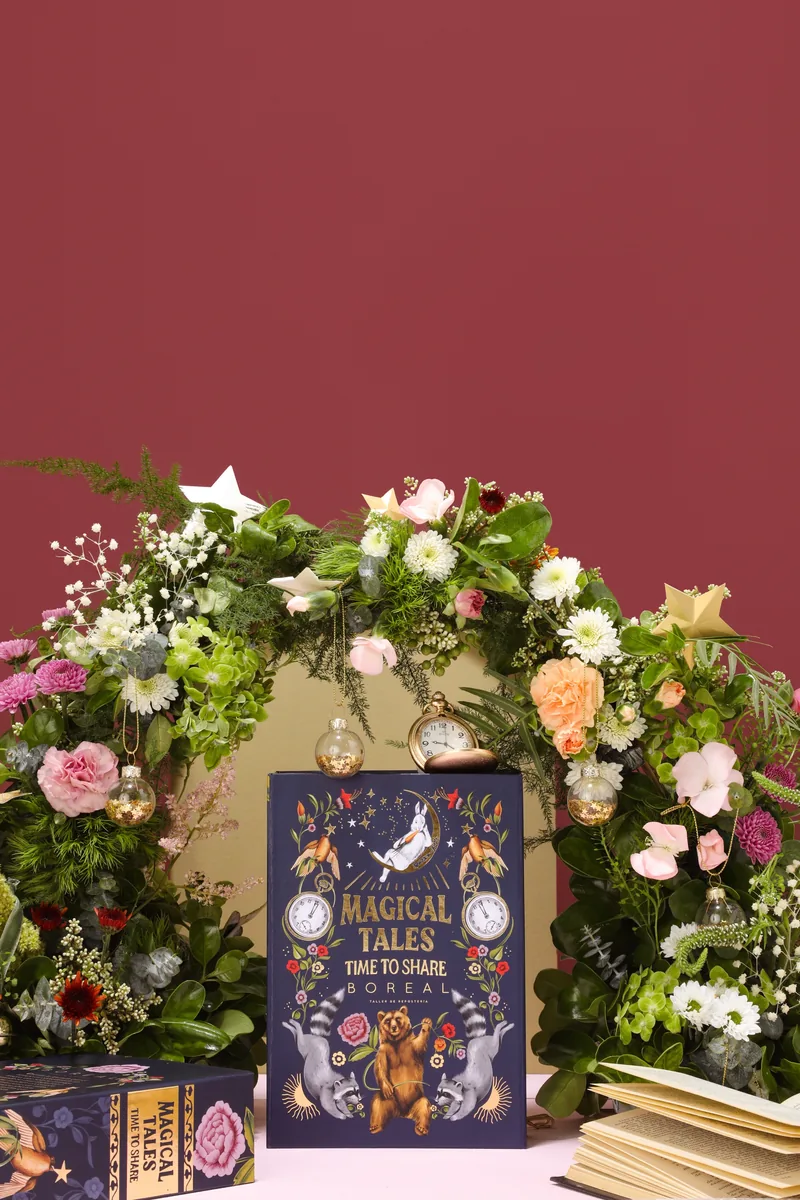 Caja «Magical Tales» de Boreal frente a un arco de flores